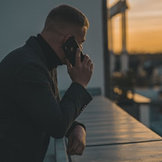 man-talking-on-phone-on-balcony